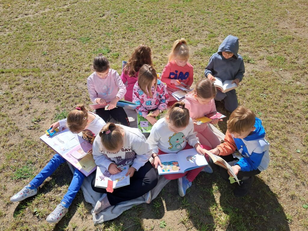 Dzieci czytająca na polanie