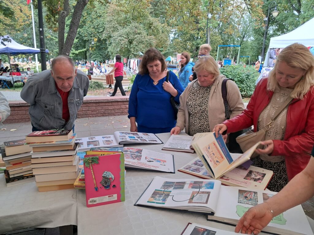 Zdjęcie przedstawia osoby oglądające kroniki biblioteki podczas FSR
